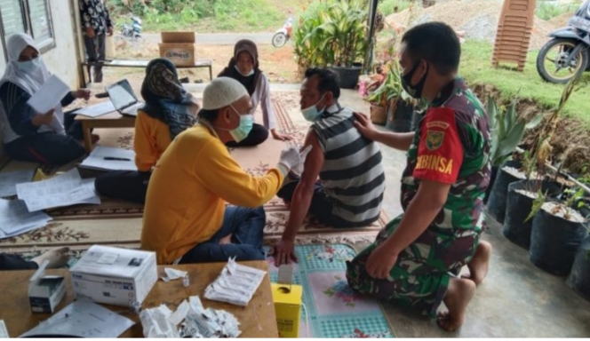 Babinsa Koramil 406-09/Terawas Serda Susnadi Monitoring Langsung Vaksinasi Massal Di Wilayah Binaan, Jum'at (17/12/2021). FOTO : PENREM 044/GAPO)