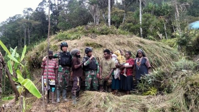 FOTO. Prajurit TNI Satgas Yonif Raider Khusus 114/SM bersama Warga foto bersama di Depan Honai di Kampung Silan Distrik Dal Kabupaten Nduga Papua.