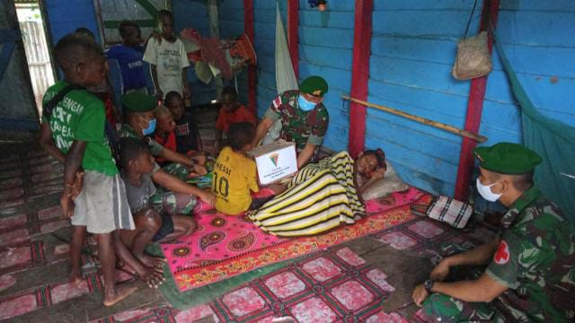 Personel Satgas Pamtas RI-PNG Yonif 123/RW Pos Rawabiru mengunjungi mama  yang menderita sakit lumpuh di rumahnya di Kampung Rawabiru, Distrik Neukenjerai Kab. Merauke, Sabtu (29/1/2022). FOTO : PENDAM CENDERAWASIH