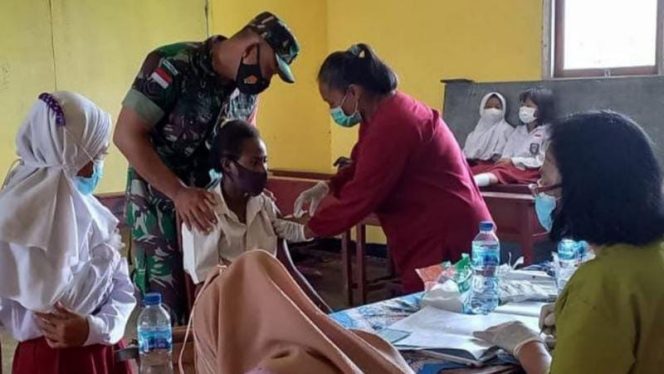 Babinsa Koramil 1707-05/Merauke, Serda Muhamad Arif melaksanakan pendampingan vaksinasi kepada siswa-siswi SD Inpres Kurik III. Rabu (23/02). FOTO : PENDAM XVII/CENDERAWASIH