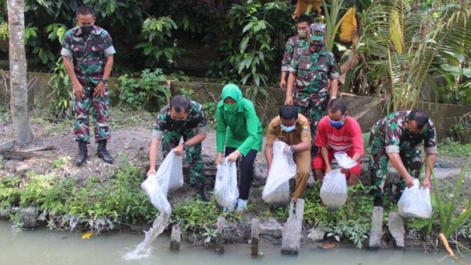 FOTO. Dandim 0415/Jambi Kolonel Czi Sriyanto semai ribuan benih ikan lele di salah satu kolam ikan milik warga di kawasan Cempaka Putih, Jelutung, Kota Jambi, Senin (7/2/2022).