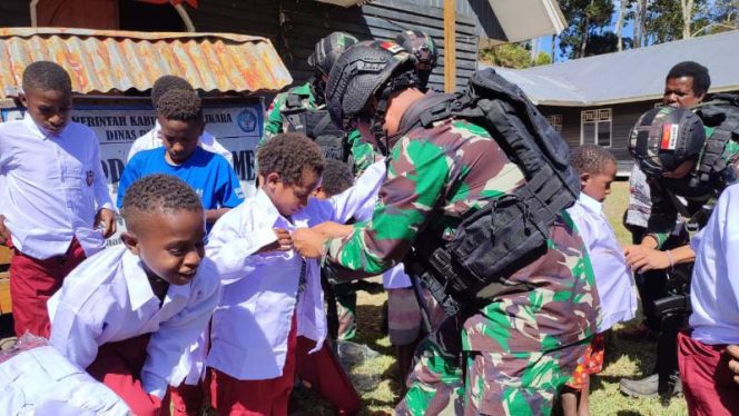 TNI Peduli Anak Papua, Satgas Yonif 142/KJ Bagikan Pakaian Seragam Dan Perlengkapan Sekolah Kepada Siswa-Siswi di Perbatasan/ FOTO : PEN SATGAS YONIF 142