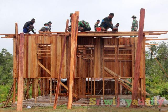 Bersama warga, Satgas TMMD Ke-113 Kodim 1707/Merauke di Kampung Vier Distrik Ti Zain Kabupaten Mappi - Papua, saat membangunan rumah type 50 yang terbuat dari kayu. (Pendam XVII/Cenderawasih