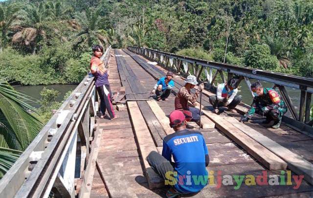 Prajurit TNI dari Kodim 0416/Bute bersama warga di Desa Tanjung Bungo, Kecamatan Limbur Lubuk Mengkuang, Kabupaten Bungo, bahu membahu  memperbaiki jembatan rusak (Sriwijayadaily)