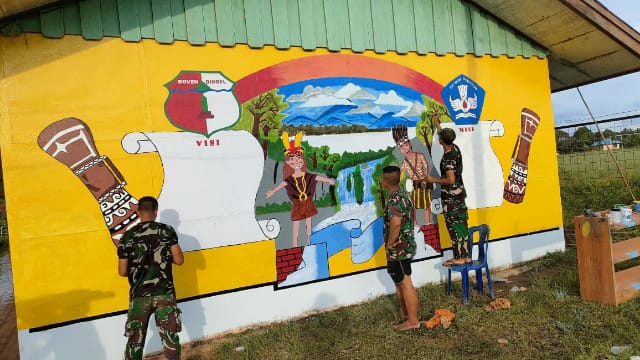 Pos Kotis Satgas Pamtas RI-PNG Yonif 725/Woroagi melukis dinding bangunan sekolah SD Inpres Asikie, Kamis (13/10/2022) / Foto. Pendam XVII/Cenderawasih.