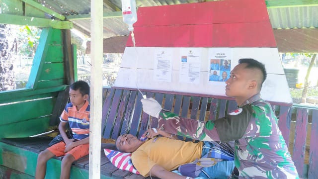 Anggota Satgas Pamtas RI-PNG Yonif 711/Rks Brigif 22/OM Pos Arso Kota dengan mengobati warga yang terjangkit malaria ( Foto. Pendam XVII/Cenderawasih).