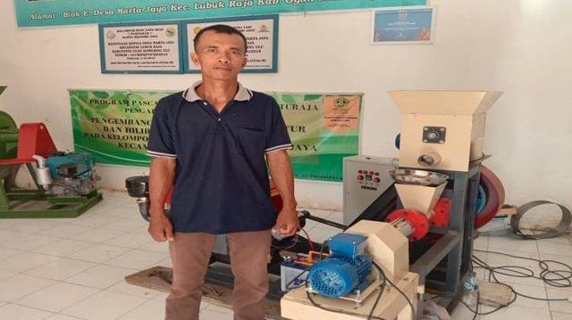 Agus Sutikno Petani Inovatif versi Tribun Sumsel bulan Juli tahun 2022 lalu, berfoto didepan mesin cetak pelet apung untuk pakan ikan ikan. (Foto. Sripoku.com)